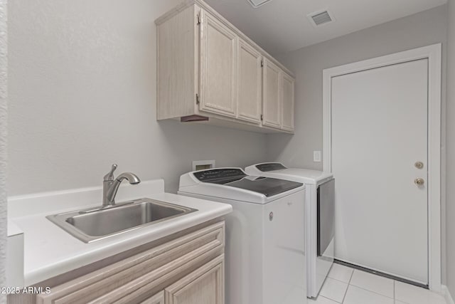 washroom with sink, cabinets, separate washer and dryer, and light tile patterned flooring