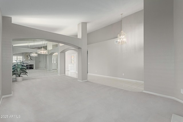 carpeted spare room featuring a chandelier