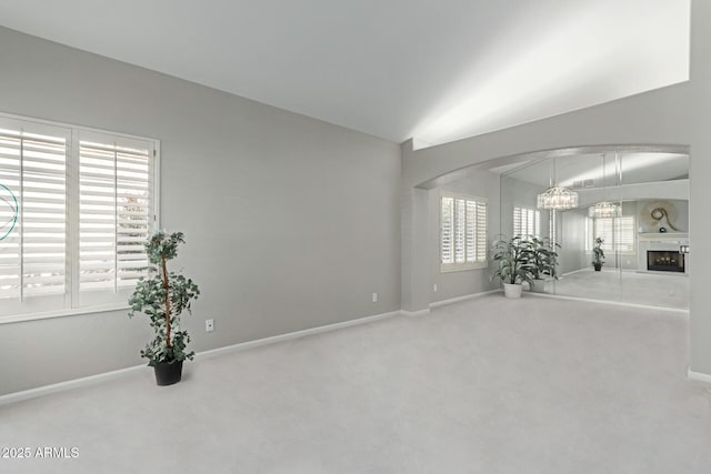 spare room featuring carpet flooring and an inviting chandelier