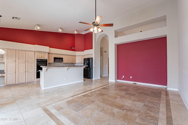 15809 S 31st St, Phoenix, AZ 85048 - kitchen featuring black appliances, high vaulted ceiling, arched walkways, baseboards, and a kitchen breakfast bar