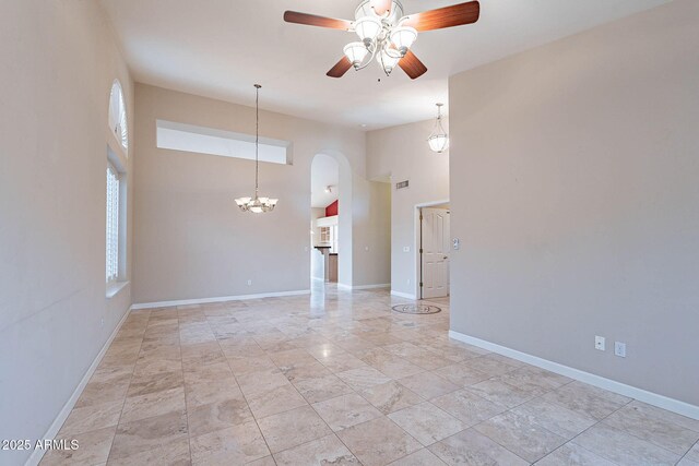 15809 S 31st St, Phoenix, AZ 85048 - spare room with arched walkways, ceiling fan, a towering ceiling, baseboards, and a chandelier