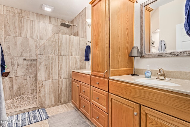 bathroom with vanity and a tile shower