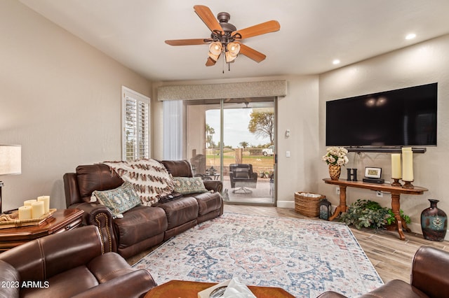 living room featuring ceiling fan and light hardwood / wood-style flooring