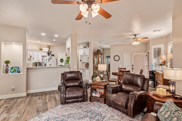 living room featuring light wood-type flooring and ceiling fan