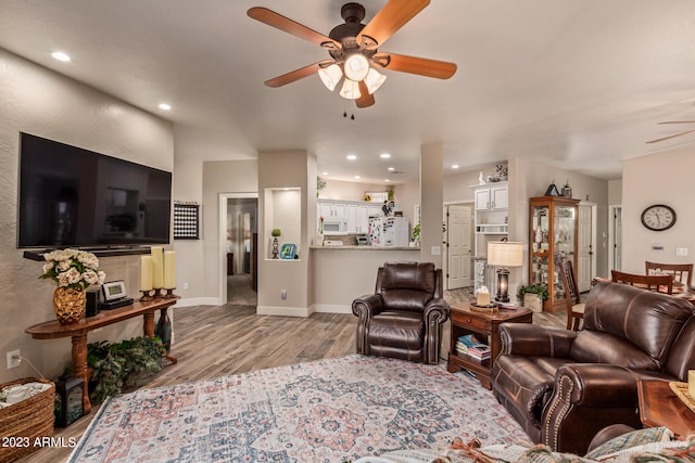 living room featuring ceiling fan and light hardwood / wood-style floors