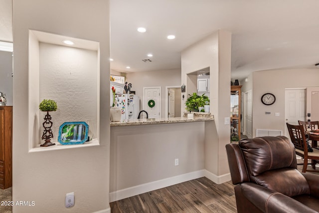 interior space with white refrigerator with ice dispenser, light stone countertops, and dark hardwood / wood-style flooring