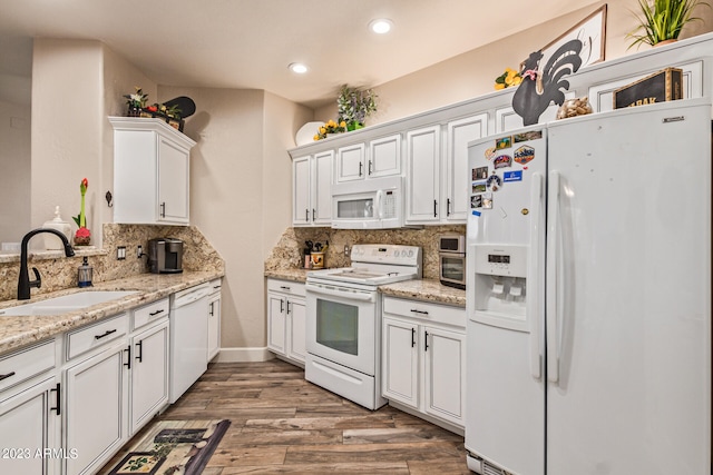 kitchen with white cabinets, sink, white appliances, backsplash, and hardwood / wood-style floors