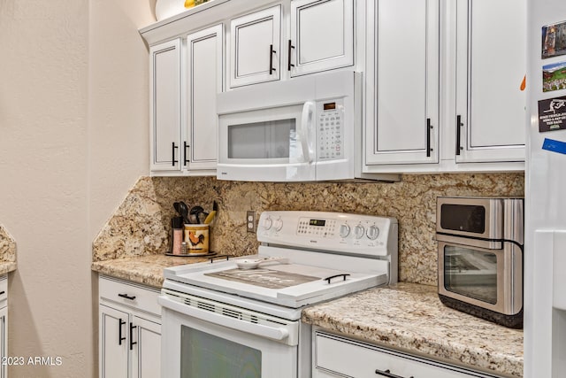 kitchen featuring light stone counters, tasteful backsplash, white appliances, and white cabinetry