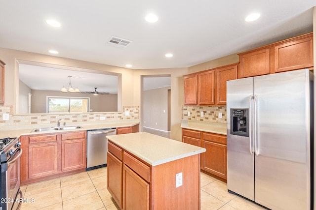 kitchen featuring sink, a center island, stainless steel appliances, pendant lighting, and light tile patterned flooring