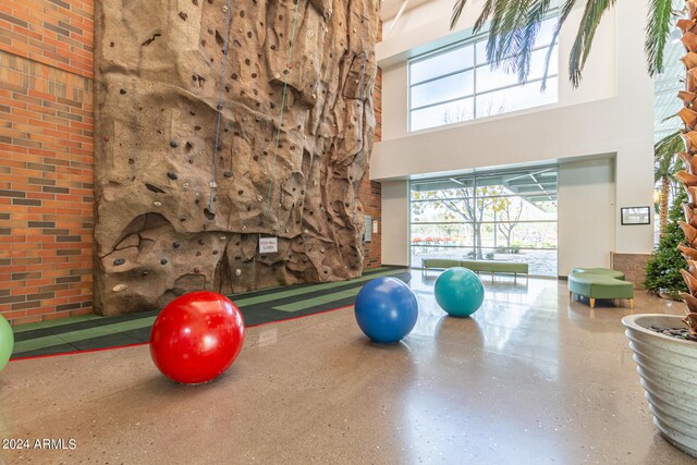 exercise area with brick wall and a high ceiling