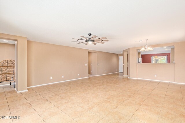 empty room featuring ceiling fan with notable chandelier