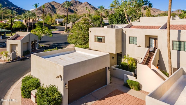 exterior space featuring a fenced front yard, a mountain view, and stucco siding