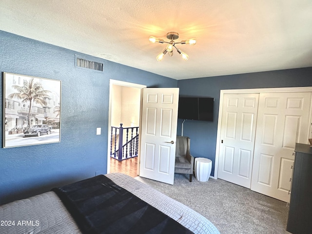 bedroom with carpet, a closet, visible vents, a textured wall, and a textured ceiling