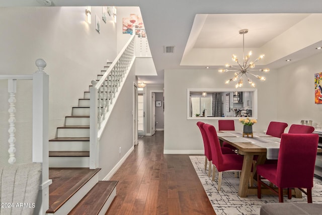 dining area with a chandelier, baseboards, stairs, a tray ceiling, and wood-type flooring