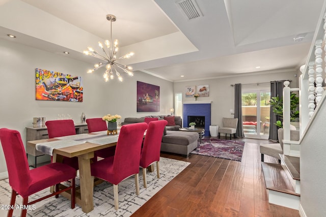 dining area featuring ornamental molding, dark wood-style flooring, a brick fireplace, and visible vents