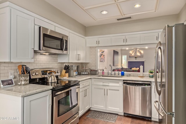 kitchen featuring visible vents, appliances with stainless steel finishes, tasteful backsplash, and a sink