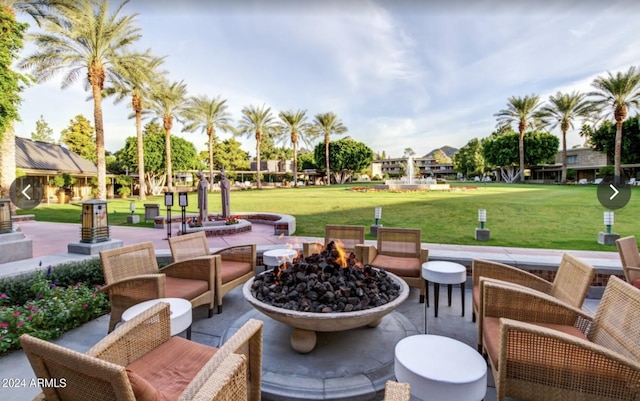 view of community featuring an outdoor living space with a fire pit, a yard, and a patio