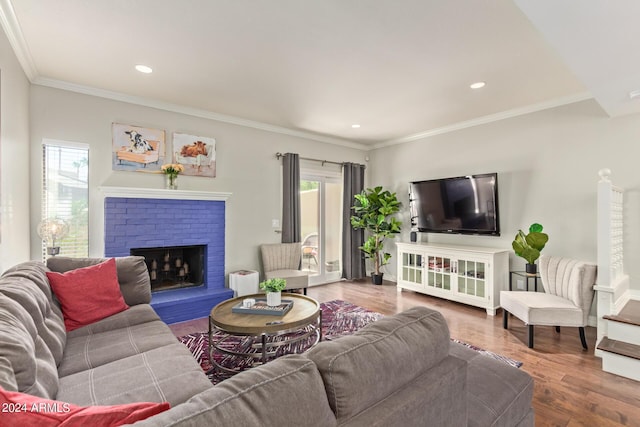 living room featuring crown molding, recessed lighting, a fireplace, and wood finished floors