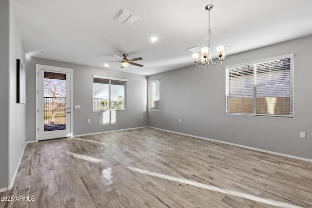 unfurnished room featuring light hardwood / wood-style flooring and ceiling fan with notable chandelier