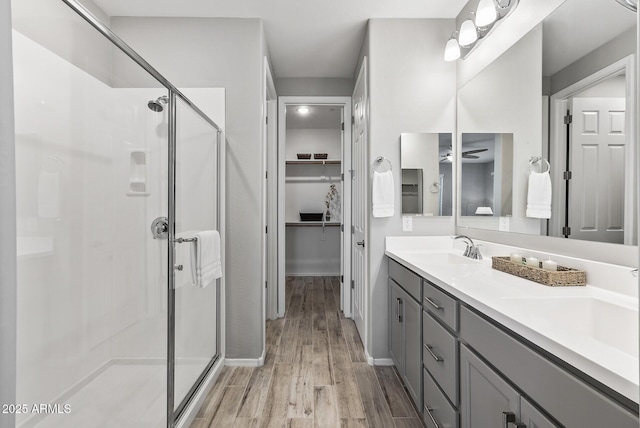 bathroom with ceiling fan, an enclosed shower, vanity, and wood-type flooring