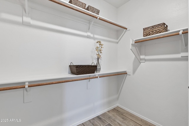 spacious closet with light hardwood / wood-style flooring