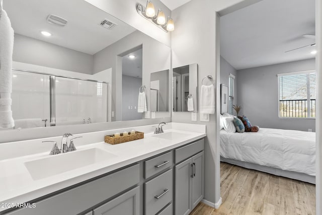 bathroom with hardwood / wood-style flooring, an enclosed shower, ceiling fan, and vanity