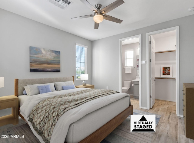 bedroom with ensuite bathroom, ceiling fan, and light hardwood / wood-style floors