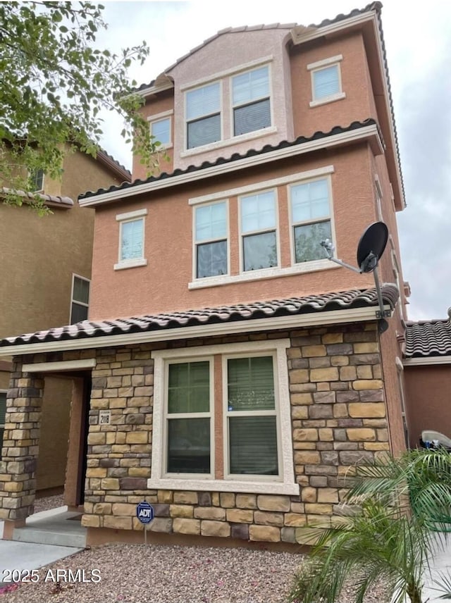 2118 N 77th Ln, Phoenix, AZ 85035 - view of front facade with stone siding, a tiled roof, and stucco siding