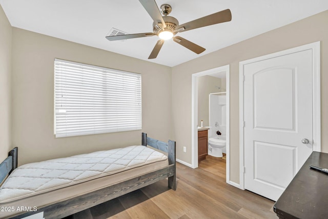 2118 N 77th Ln, Phoenix, AZ 85035 - bedroom featuring wood finished floors, baseboards, ensuite bath, and ceiling fan