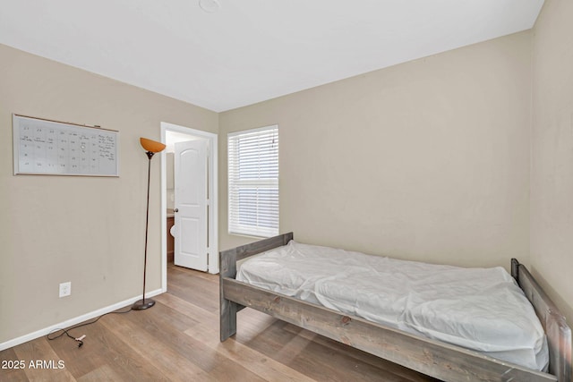 2118 N 77th Ln, Phoenix, AZ 85035 - bedroom with baseboards and wood finished floors