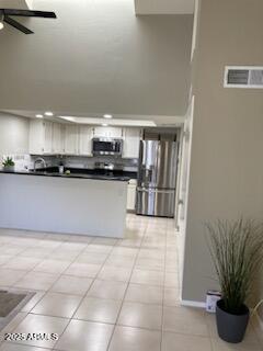 kitchen with light tile patterned floors, ceiling fan, appliances with stainless steel finishes, white cabinetry, and kitchen peninsula