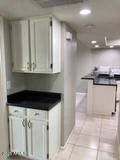 kitchen with light tile patterned floors and white cabinets