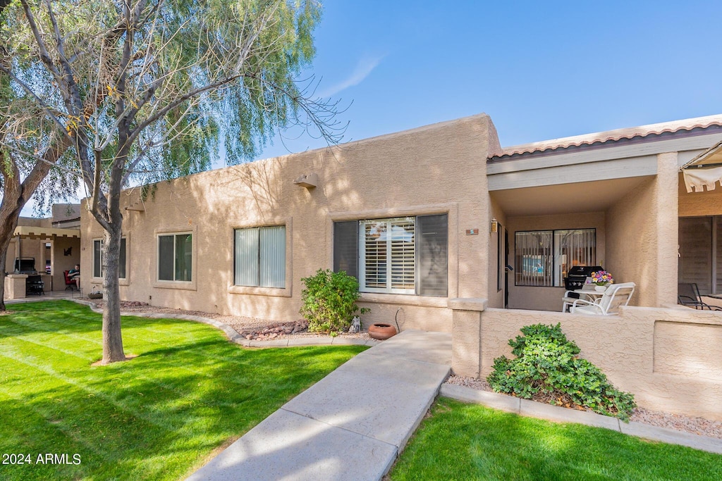 view of front of home with a front yard and a patio