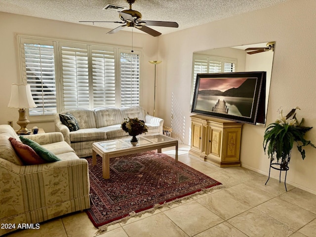 living room featuring light tile patterned flooring, a textured ceiling, ceiling fan, and a wealth of natural light