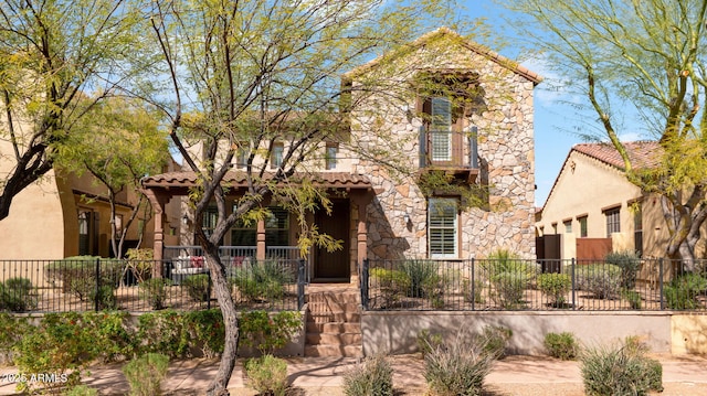 view of front of house with a fenced front yard, stucco siding, a porch, stone siding, and a tiled roof