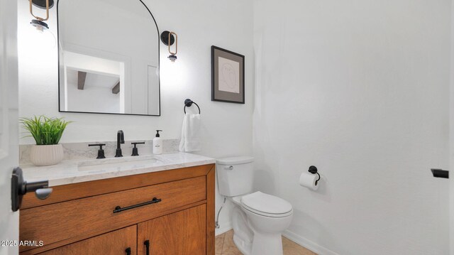 bathroom with baseboards, vanity, and toilet