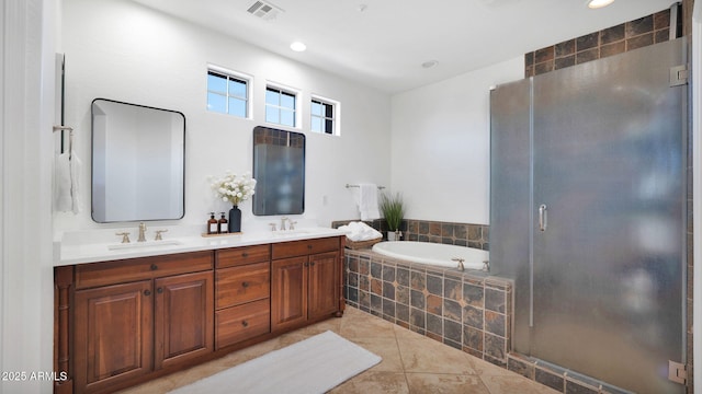 bathroom with a garden tub, visible vents, a sink, and a stall shower