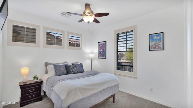 carpeted bedroom featuring ceiling fan, visible vents, and baseboards