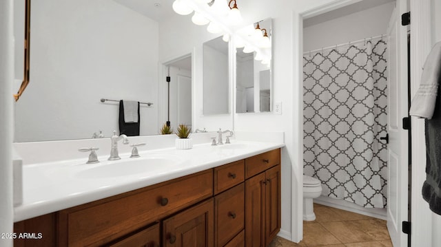 full bathroom with tile patterned flooring, a sink, toilet, and double vanity