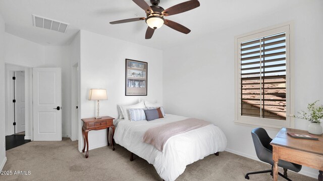 bedroom featuring baseboards, visible vents, a ceiling fan, and light colored carpet