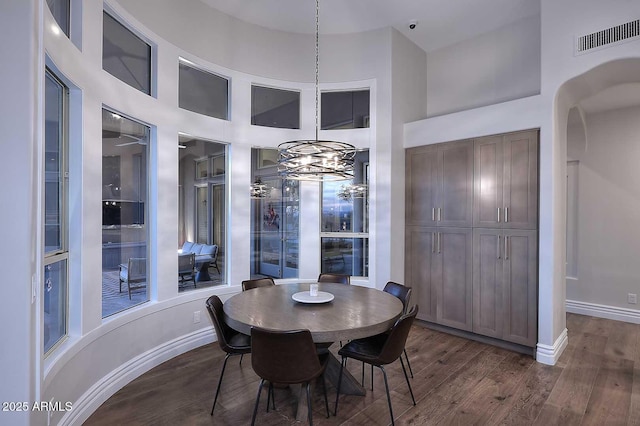 dining area with a chandelier, dark hardwood / wood-style floors, and a high ceiling