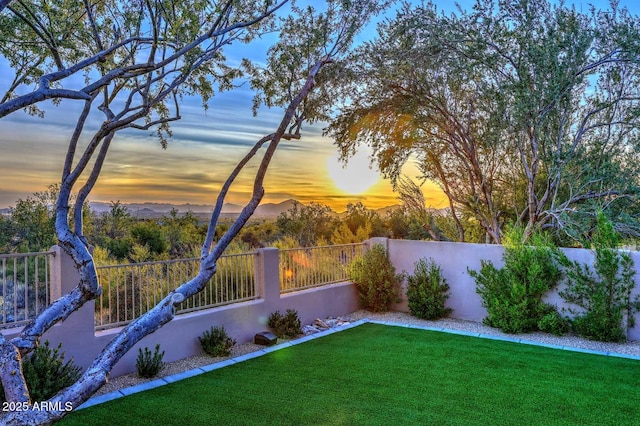 yard at dusk featuring a mountain view