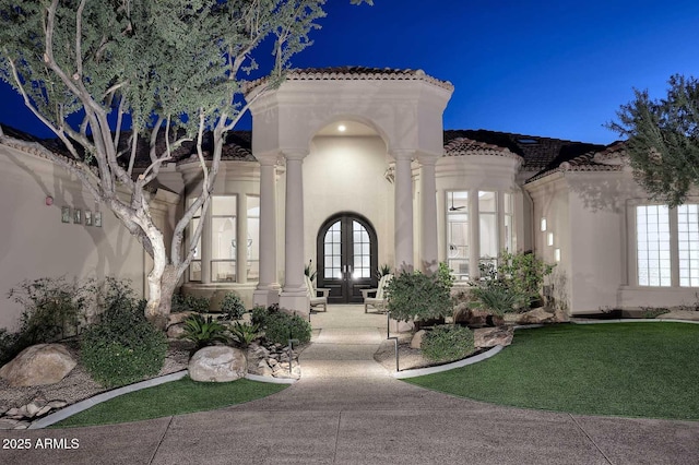 entrance to property featuring a yard and french doors