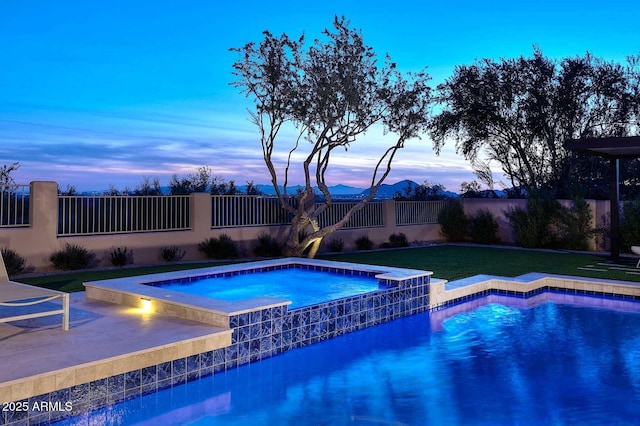 pool at dusk with an in ground hot tub