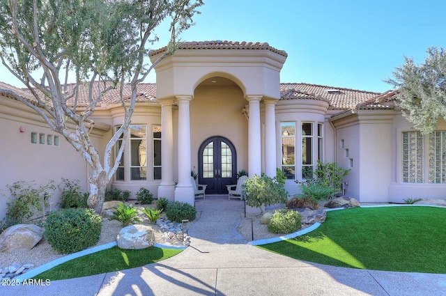 property entrance with french doors and a lawn