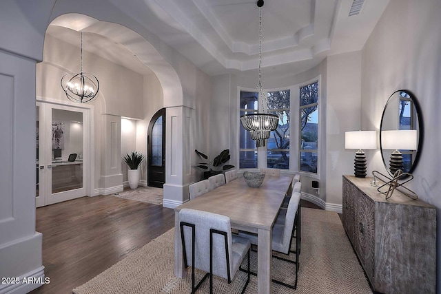 dining area with dark hardwood / wood-style floors and a chandelier