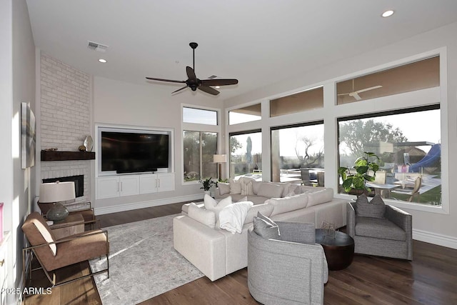 living room with a healthy amount of sunlight, dark hardwood / wood-style floors, and ceiling fan