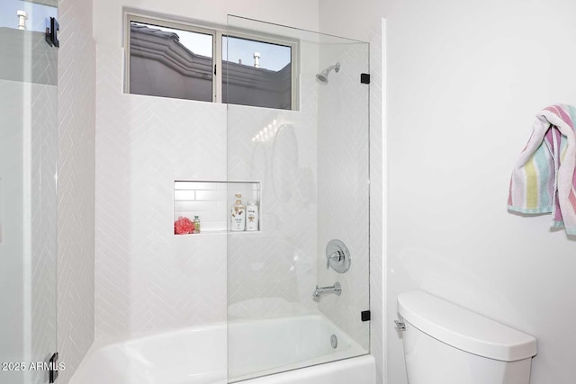 bathroom with tiled shower / bath combo and toilet