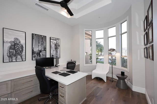 home office featuring ceiling fan, a raised ceiling, and dark hardwood / wood-style flooring