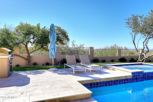 view of swimming pool with an in ground hot tub, grilling area, and a patio